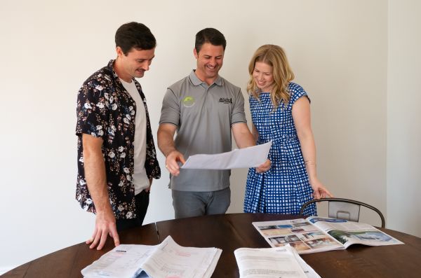 Paul Bateman, managing Director of Alpha 1 Builders with two happy clients